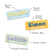 A display of personalised name labels featuring a selection of colours for custom badges and work plates.